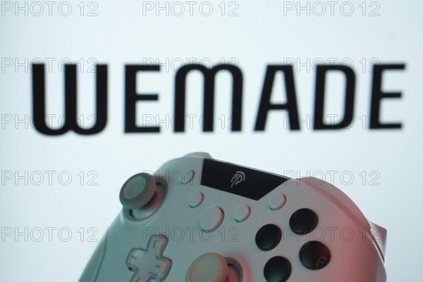 Dhaka, Bangladesh- 14 Nov 2025: A close-up of a gamepad with the WeMade Entertainment seen on screen in the background