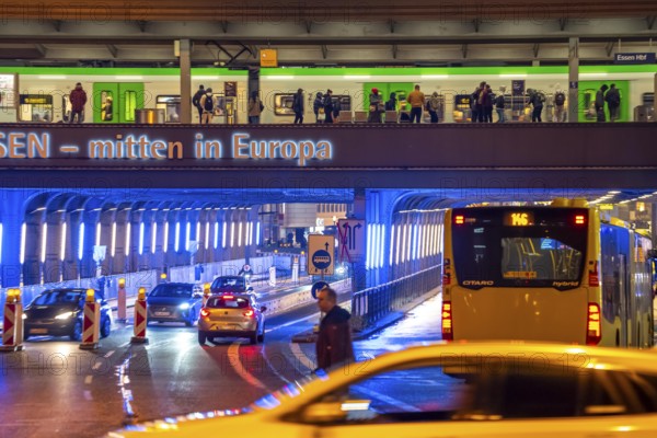 The main train station in Essen, blue illuminated underpass, bus station, am Europaplatz, train on the platform, North Rhine-Westphalia, Germany