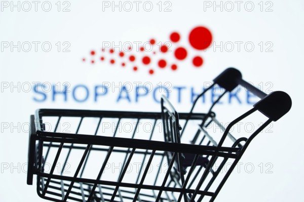 Dhaka, Bangladesh- 21 Nov 2025: Silhouette of a shopping cart in front of the Shop Apotheke logo, symbolizing ecommerce and online shopping