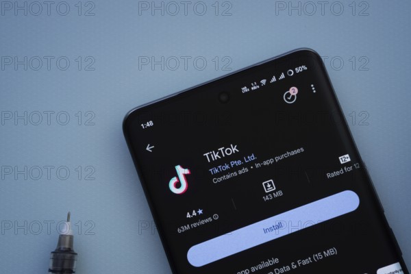Dhaka, Bangladesh- 29 May 2025: On a blue surface, a smartphone displays the TikTok app within the Google Play Store
