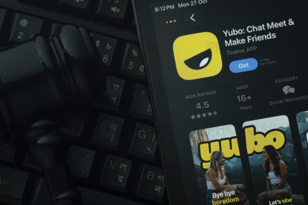 Dhaka, Bangladesh- 28 Oct 2025: An iPad displaying the Yubo app against a judge's gavel and dark keyboard background