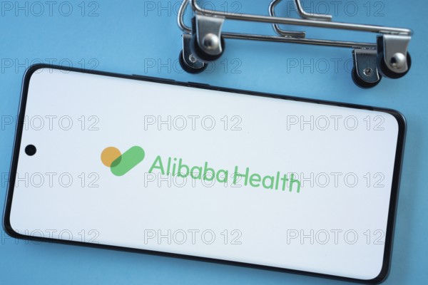Dhaka, Bangladesh- 21 Nov 2025: Smartphone screen showing the Alibaba Health logo with shopping cart wheels on a blue background