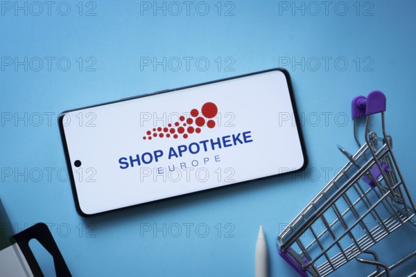 Dhaka, Bangladesh- 03 July 2025: Smartphone displaying (...) logo with shopping cart on a blue background
