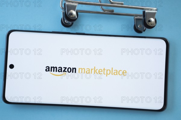 Dhaka, Bangladesh- 21 Nov 2025: Smartphone screen showing the amazon marketplace logo with shopping cart wheels on a blue background