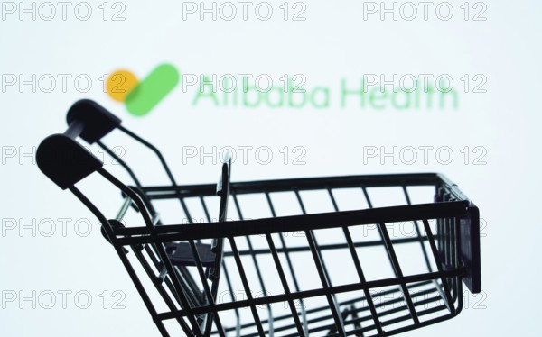 Dhaka, Bangladesh- 21 Nov 2025: Silhouette of a shopping cart in front of the Alibaba Health logo, symbolizing ecommerce and online shopping