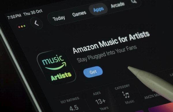 Dhaka, Bangladesh- 21 Nov 2025: Amazon Music for Artist app displayed on a iPad screen in dark mode with a digital pen pointing at it