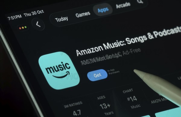 Dhaka, Bangladesh- 21 Nov 2025: Amazon Music app displayed on a iPad screen in dark mode with a digital pen pointing at it