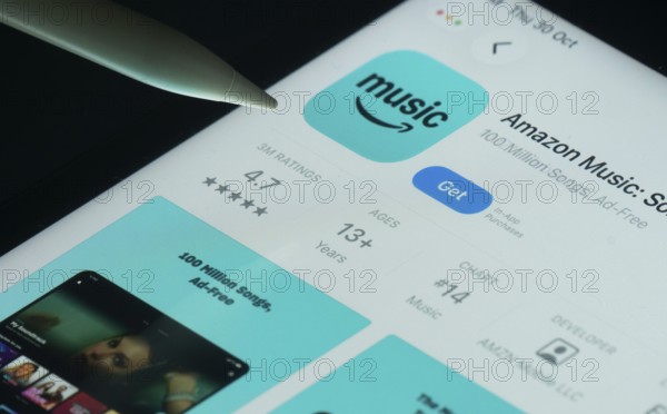 Dhaka, Bangladesh- 21 Nov 2025: Amazon Music app on a iPad screen with a pen pointing at the install option