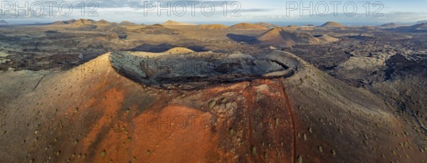 Caldera Colorada volcano, picturesque volcanic landscape with volcanic craters and lava fields in morning light, Parque Natural de Los Volcanes, aerial view, Lanzarote, Canary Islands, Spain