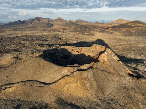 Volcán de Las Nueces volcano, picturesque volcanic landscape with volcanic craters and lava fields in morning light, Parque Natural de Los Volcanes, aerial view, Lanzarote, Canary Islands, Spain