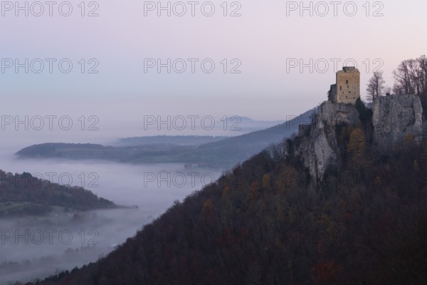 Sunrise with fog in the Neidlinger Valley with a view of the Reussenstein castle ruins. Swabian Jura, Baden-Württemberg, Germany
