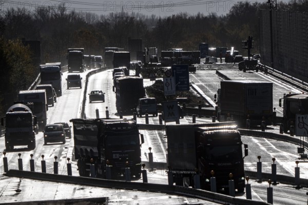 Highway construction site, the A57 is extended to 6 lanes on the section between the Meerbusch motorway junction and the Oppum junction, traffic runs parallel to 2 narrowed lanes, wet road after rain shower, Krefeld, North Rhine-Westphalia, Germany