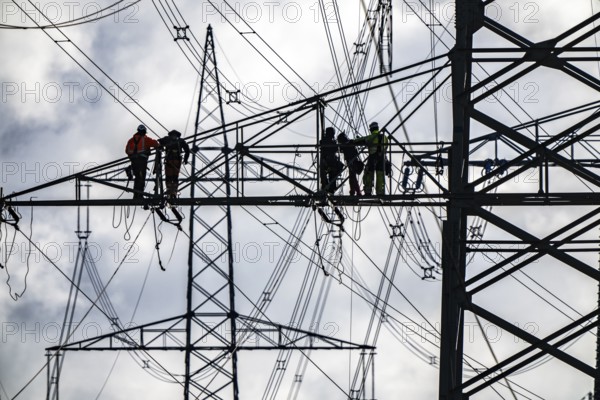 Work on a 380 kV high-voltage overhead line, new construction, along the A57 motorway, near Meerbusch, workers on the boom of the high-voltage pylon, North Rhine-Westphalia, Germany