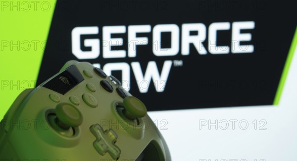 Dhaka, Bangladesh- 14 Nov 2025: A close-up of a gamepad with the Geforce Now seen on screen in the background