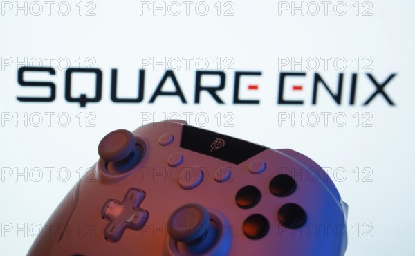 Dhaka, Bangladesh- 14 Nov 2025: A close-up of a gamepad with the Square Enix seen on screen in the background