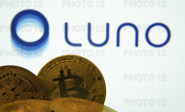 Dhaka, Bangladesh- 03 Sep 2025: Close-up of Bitcoin coins with the Luno logo visible on a screen in the background