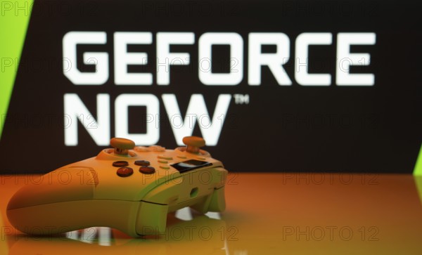 Dhaka, Bangladesh- 14 Nov 2025: A close-up of a white gamepad with the Geforce Now seen on screen in the background