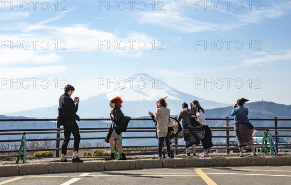 Tourists enjoy the view and take pictures, view of the snow-covered summit of Mount Fuji volcano in spring, Owakudani, Hakone, Japan