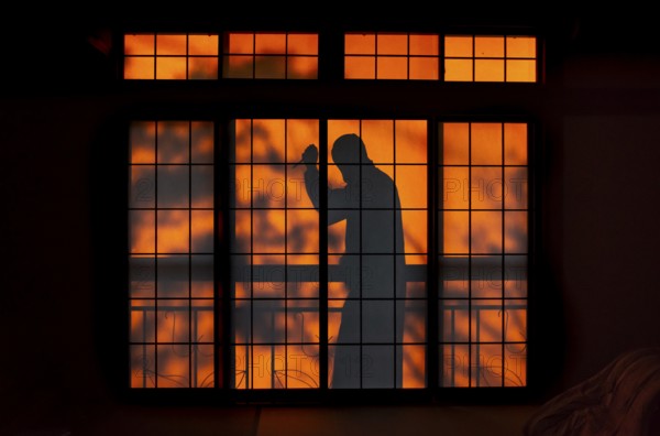 Shadow of a man, burglar with knife, assassin, ninja, on the balcony behind sliding shoji doors in a traditional Japanese house, Yamanouchi, Nagano, Japan