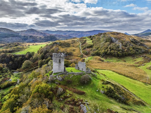 Autumn colours over Castell Dolwyddelan and Eryri Mountains from a drone, Snowdonia, Conwy County Borough, Wales, England, United Kingdom