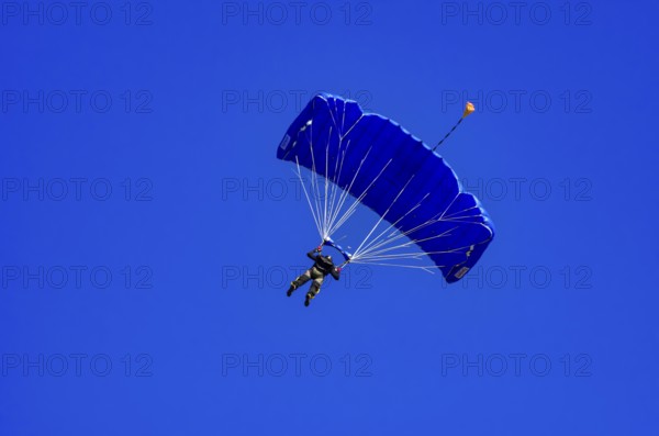 Skydivers during an aerial acrobatic performance as part of an air show at the Fliegerbergfest of the Rossfeld Luftsportverein in Metzingen-Glems, Baden-Württemberg, Germany, for editorial use only