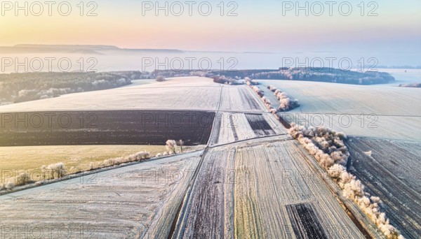 Bird Eye Perspective of Frost Covered Farmland. Seasonal Agricultural Scenery, winter and autumn scene, blue sky with golden light at sunrise, AI generated
