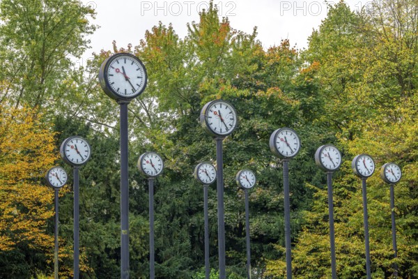 The art installation Zeitfeld in Volksgarten Park in Düsseldorf-Oberbilk, a total of 24 station clocks, on 6 meter high steel columns, have been running synchronously since 1987, artwork by Düsseldorf artist Klaus Rinke, symbol of time, time change, North Rhine-Westphalia, Germany