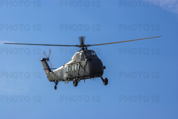 A Sikorsky S-58C transport helicopter in the colours of the German Army with the registration D-HAUG during a flight demonstration as part of an air show at the Rossfeld in Metzingen-Glems, Baden-Württemberg, Germany, for editorial use only