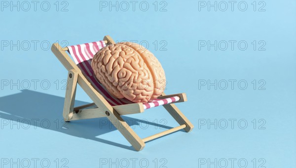 Brain relaxes on a sunbed under the summer sun, placed on a flat surface, symbol for mental health, AI generated