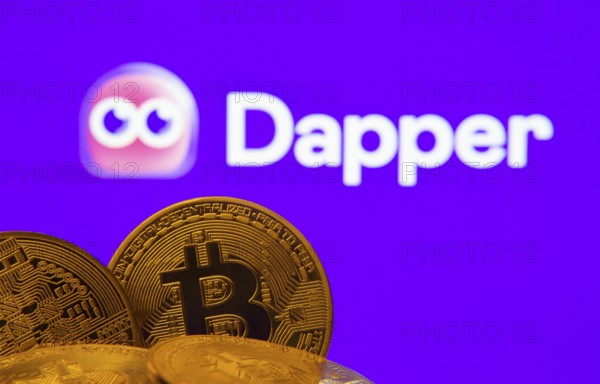Dhaka, Bangladesh- 03 Oct 2025: Close-up of Bitcoin coins with the Dapper logo visible on a screen in the background