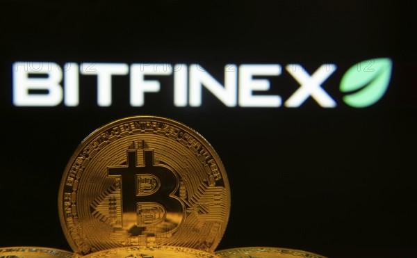 Dhaka, Bangladesh- 15 June 2025: Close-up of Bitcoin coins with the Bitfinex logo visible on a screen in the background