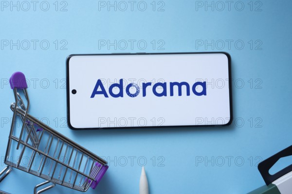 Dhaka, Bangladesh- 03 July 2025: Smartphone displaying Adorama logo with shopping cart on a blue background
