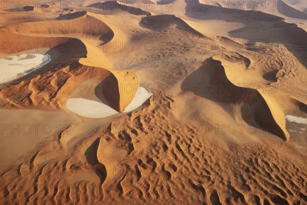 Sand dunes and dry pans in the Namib Desert. In the evening. Aerial view. Namib-Naukluft Park, Namibia