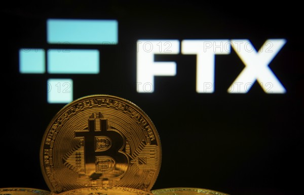 Dhaka, Bangladesh- 03 Sep 2025: Close-up of Bitcoin coins with the FTX logo visible on a screen in the background