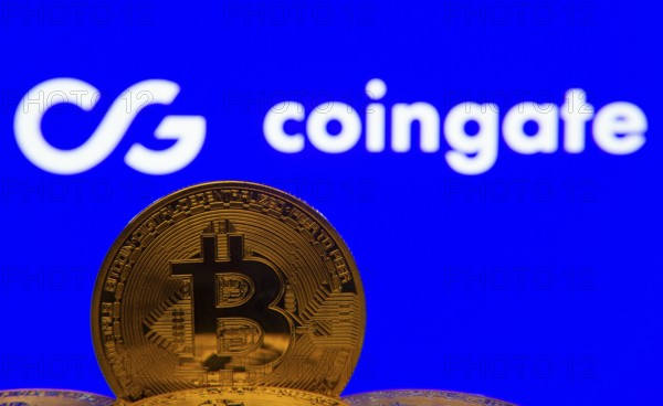 Dhaka, Bangladesh- 03 Sep 2025: Close-up of Bitcoin coins with the Coingate logo visible on a screen in the background