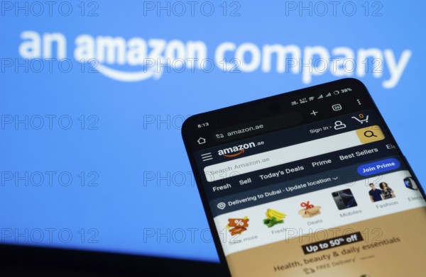 Dhaka, Bangladesh- 03 July 2025: Smartphone displaying Amazon web interface against Amazon logo background