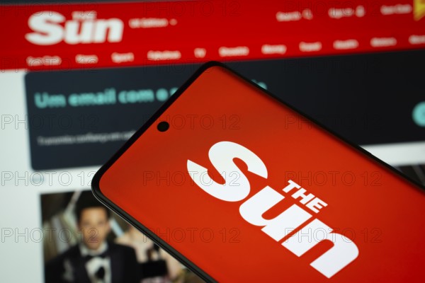 Dhaka, Bangladesh - 18 March 2025: The logo of the sun is displayed on a smartphone screen, and the website is visible on a computer screen in the background