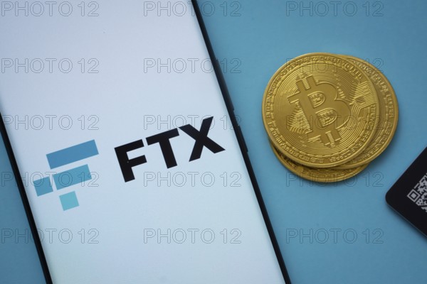Dhaka, Bangladesh- 03 Sep 2025: FTX logo on smartphone screen near Bitcoin coin and QR code on blue background
