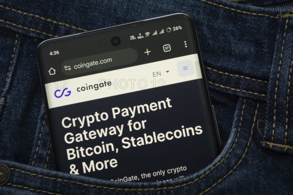 Dhaka, Bangladesh- 15 June 2025: A smartphone displaying the Coingate web interface peeks out of a denim pocket