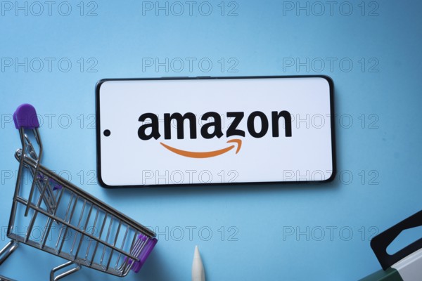 Dhaka, Bangladesh- 03 July 2025: Smartphone displaying Amazon logo with shopping cart on a blue background