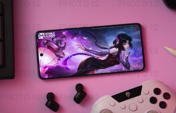 Dhaka, Bangladesh- 25 Aug 2025: A close-up of a gamepad with the Mobile Legends Bang Bang seen on smartphone