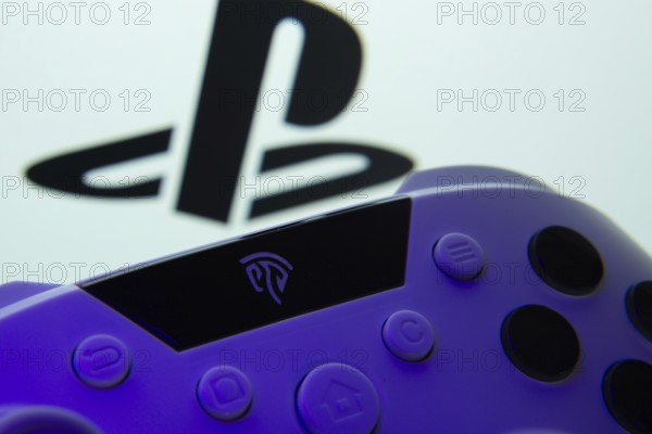 Dhaka, Bangladesh- 15 Aug 2025: A close-up of a gamepad with the PlayStation seen on screen in the background