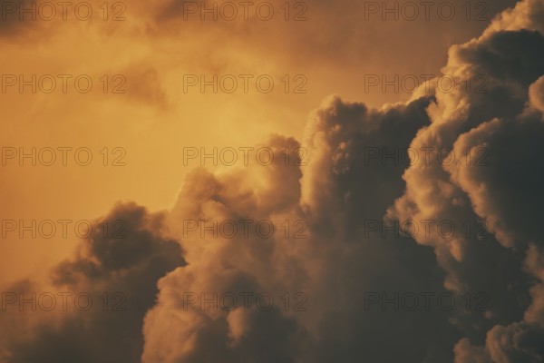 Warm orange sunset clouds with a dramatic and fluffy appearance against the sky