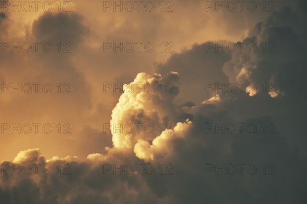 Dramatic sunset clouds with warm orange hues creating a fluffy and atmospheric scene