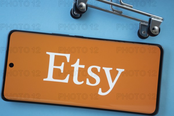 Dhaka, Bangladesh- 03 July 2025: Smartphone screen showing the Etsy logo with shopping cart wheels on a blue background