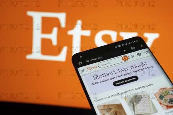 Dhaka, Bangladesh- 03 July 2025: Smartphone displaying Etsy web interface against Etsy logo background