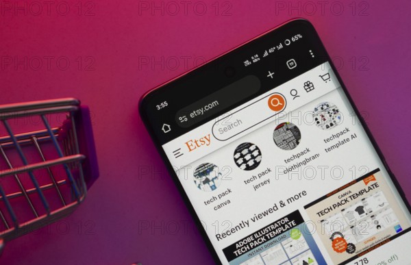 Dhaka, Bangladesh- 23 June 2025: A smartphone displaying the Etsy website with a shopping cart is shown on a vibrant background