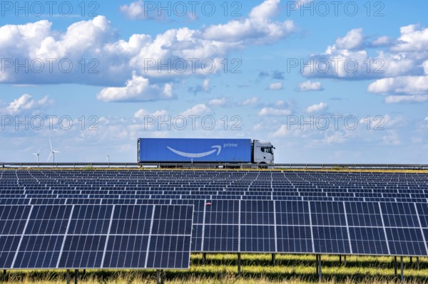86, 5 MW peak ground-mounted photovoltaic systems, by RWE, with over 141, 000 solar modules, on a verge, over 1 km long, along the A44 motorway near Bedburg, at the Jackerath junction, recultivated open-cast mining site, field with sunflowers, North Rhine-Westphalia, Germany