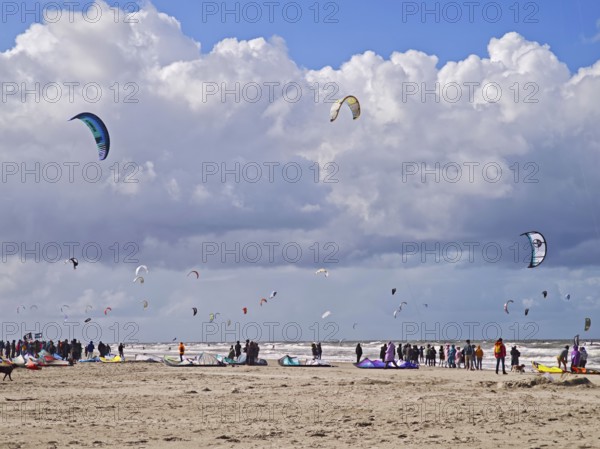 California kitesurfing Masters 2025 at the edge of the UNESCO World Heritage Wadden Sea, North Sea, kitesurfing sport, flying kites, spectators, fun, competition, strong wind, whitecaps, beach, summer, sunshine, blue sky, white clouds, Ording, Sankt Peter-Ording, Schleswig-Holstein, Germany