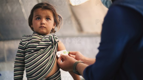 A doctor examines children's malnutrition inside a refugee camp. Malnutrition was measured using a mid-upper arm circumference belt. Aleppo, Syria October 29, 2022, Aleppo, Syria
